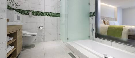 A modern bathroom with a glass-enclosed shower, a large mirror, and a bathtub.