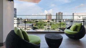 A balcony with wicker furniture and a city view. - CHECK inn MAGI Kids (Luodong)