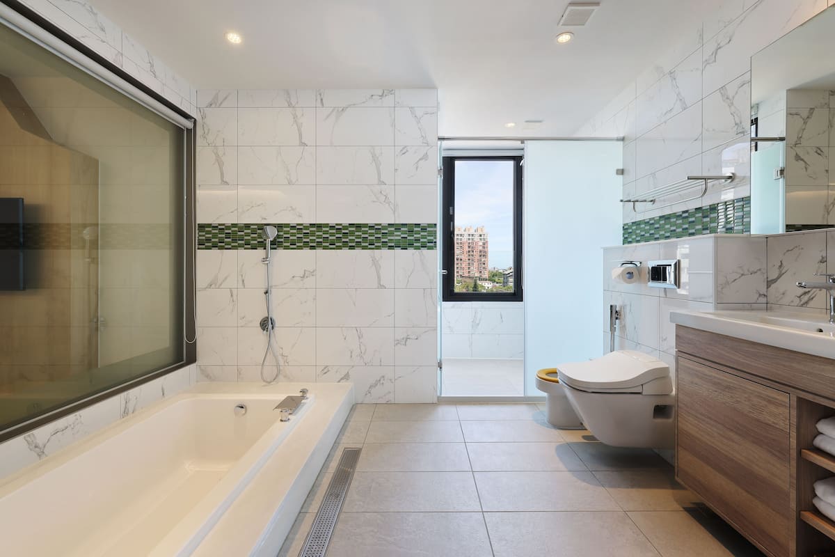 deluxe quadruple room | bathroom | hair dryer, towels, shampoo, toilet paper