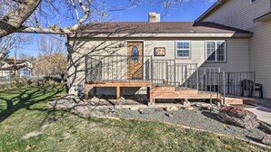 A two-story house with a wooden deck, a garage, and a stone pathway. - 'The Cabin' at Grand Valley Getaway w/ Grill! (Grand Junction)