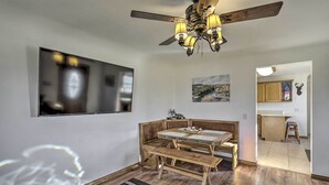 A dining area with a wooden bench and table, a ceiling fan, and artwork on the walls. - 'The Cabin' at Grand Valley Getaway w/ Grill! (Grand Junction)