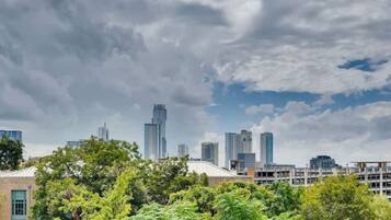 A city skyline with modern high-rise buildings and a mix of greenery in the foreground.