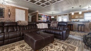 A spacious living room with a large sectional sofa, a matching ottoman, and a patterned rug. - The Key to your Heart (Nixa)