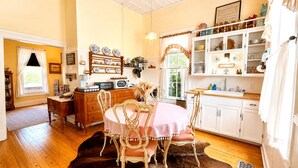Une cuisine chaleureuse avec des meubles de rangement en bois, une table à manger avec des chaises et un lustre.