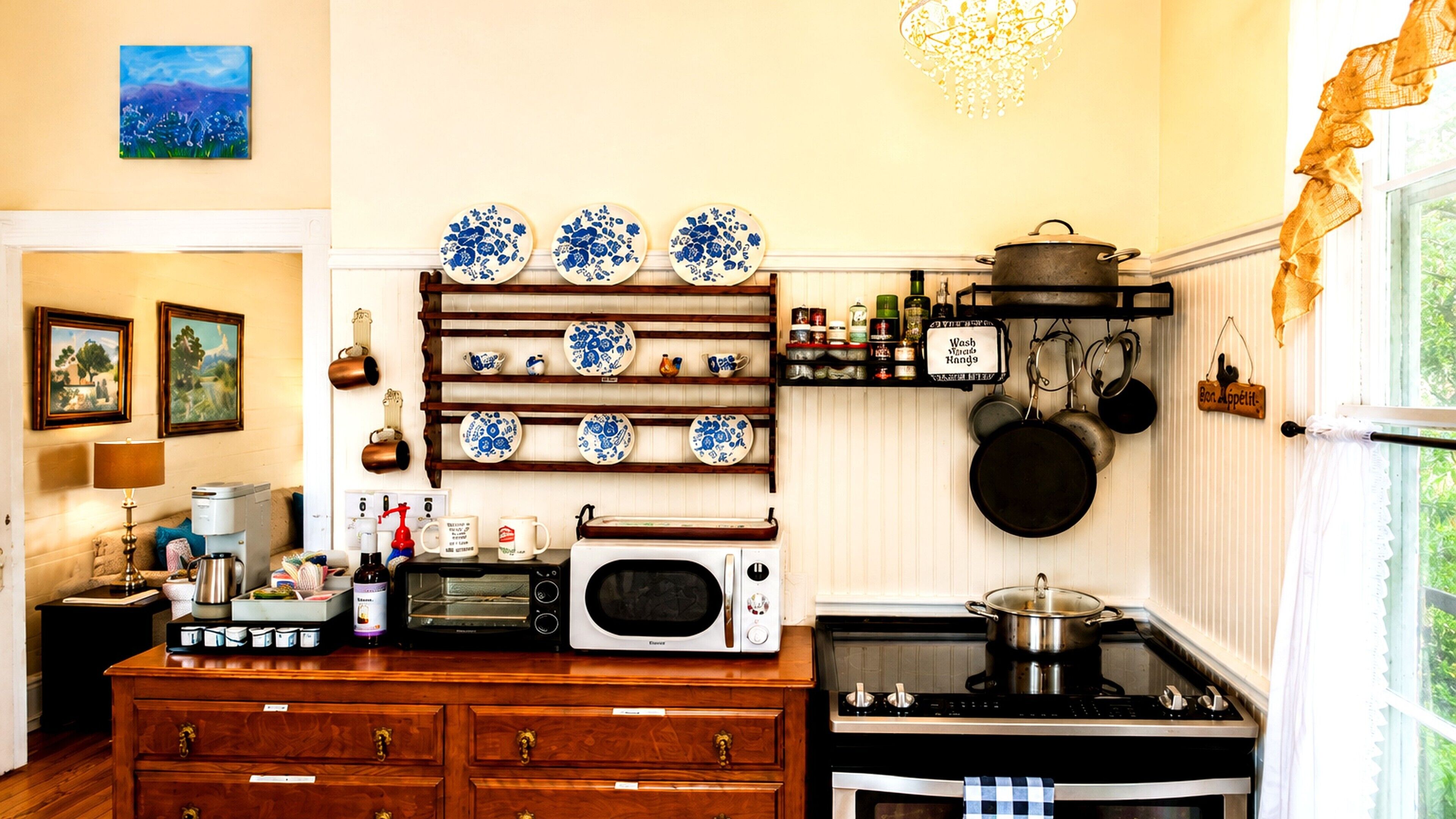 Een keuken met een houten aanrecht, een magnetron, een fornuis en een hangende pannendroger.