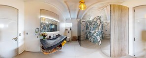 Features a sleek vanity, large mirror, and separate shower area.