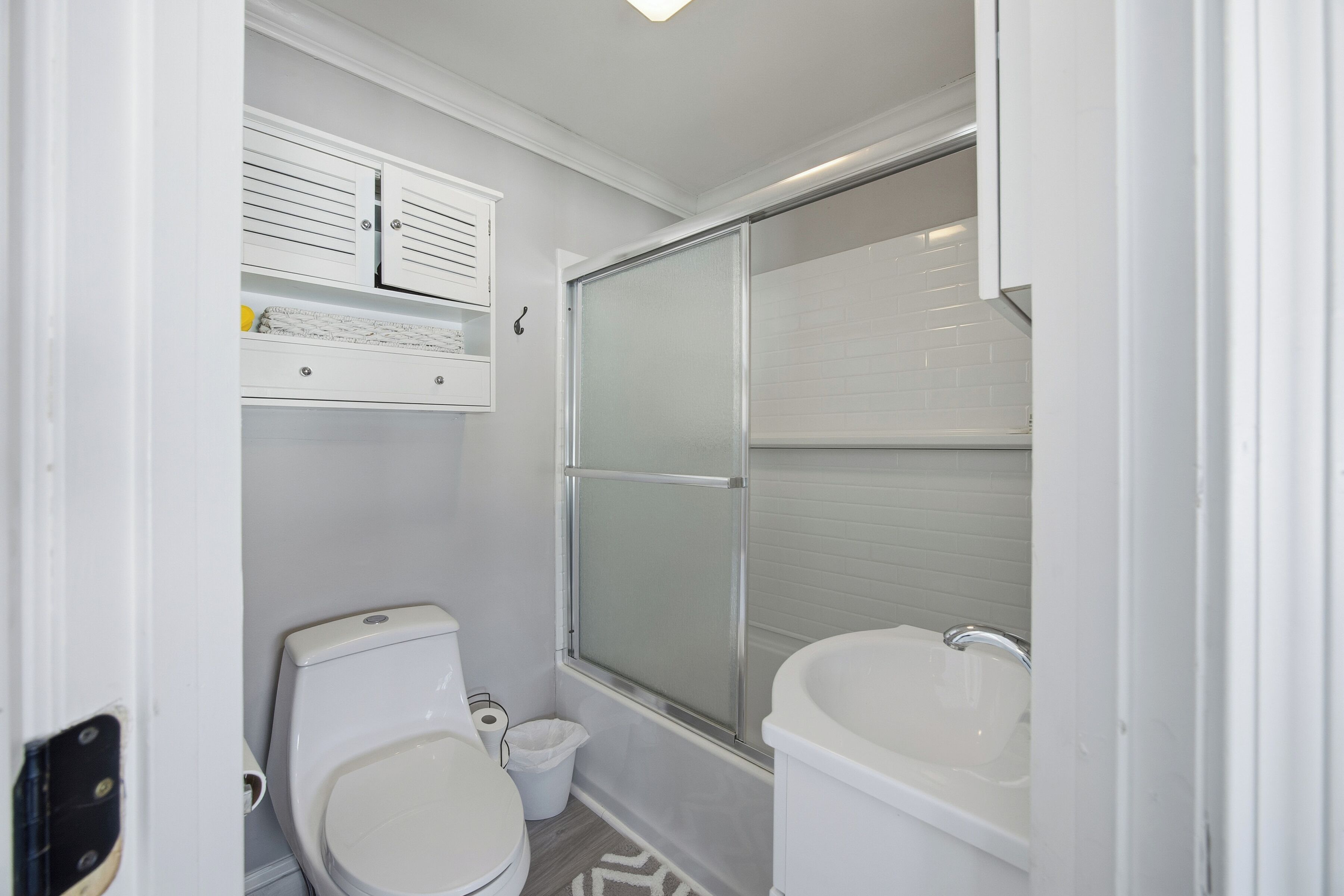 A compact bathroom with a toilet, a shower enclosure, and a bathtub.