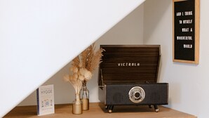 Ein Kamin mit modernem Design, ein Vintage-Radio und Dekorationen auf einem Holzboden.