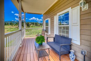 A wooden porch with a table, chairs, and a potted plant. - Scenic Sanctuary: Monthly Stay, Spectacular Mtn View, Gas Firepit, 10 Min to Downtown Pagosa Springs (Pagosa Springs)
