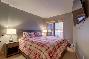 A bedroom with a bed, nightstands, lamps, a TV, and a window. - Perfect Ski Condo Steps from the Super Bee & Golf Course - CS325 by Redawning (Copper Mountain)