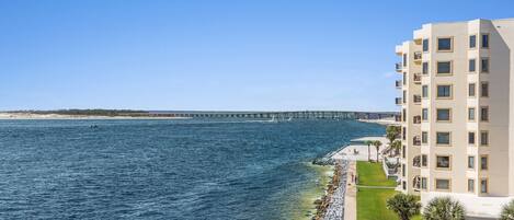 A coastal hotel with a view of the ocean and a pier in the background.