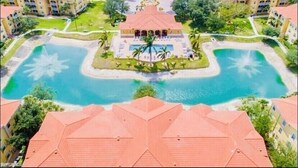 A resort with multiple buildings, a central pool, and surrounding greenery. - LOVELY RESIDENCE CONDO TROPICAL RETREAT! (Fort Myers)