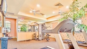 A gym with exercise equipment, a large mirror, and a ceiling fan. - LOVELY RESIDENCE CONDO TROPICAL RETREAT! (Fort Myers)