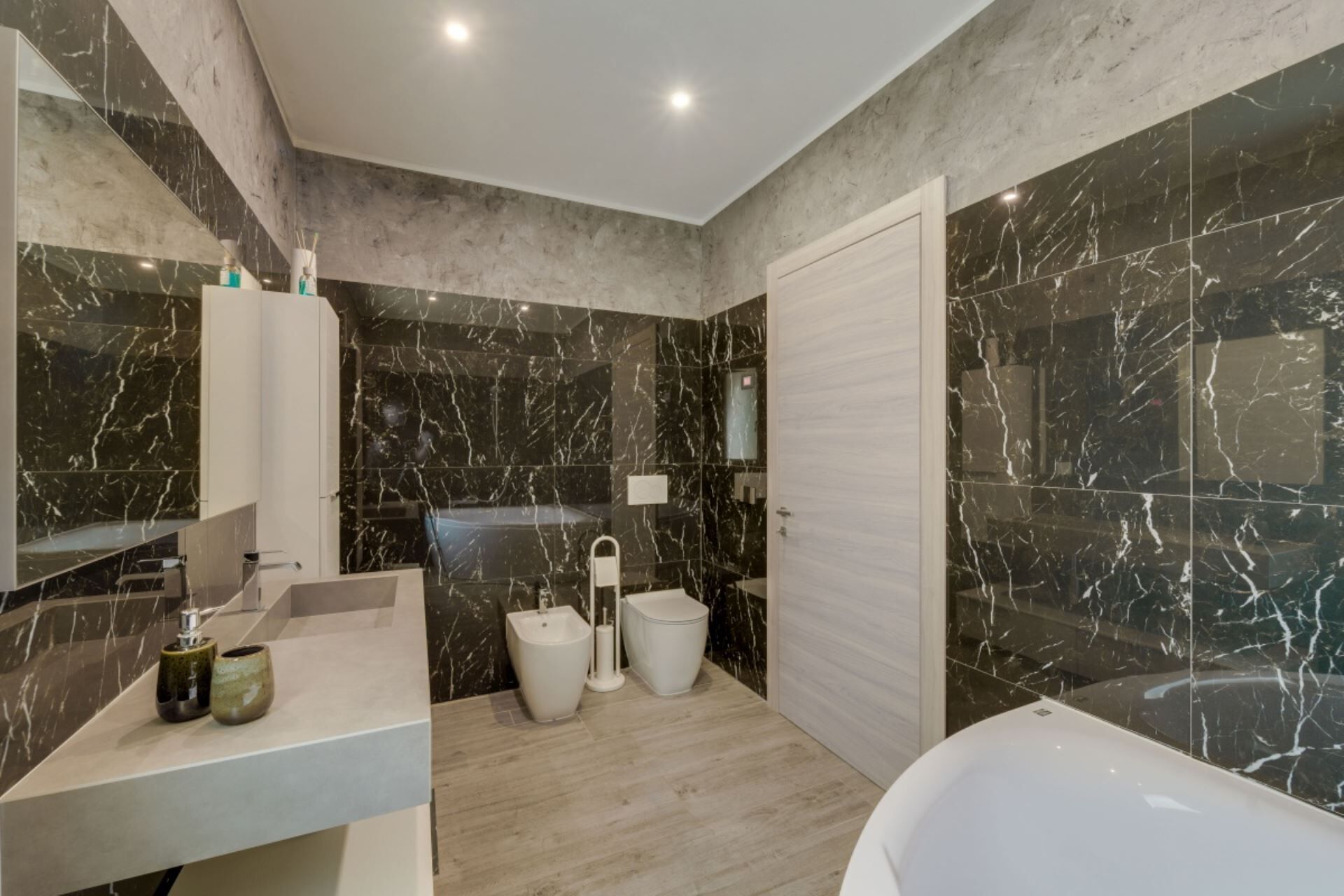 Ein modernes Badezimmer mit Marmorwaschtisch, Bidet, Toilette und Badewanne.