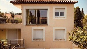 A two-story building with a tiled roof, a balcony, and a garage. - Bastide standing CLIMATISÉ center town à PIEDS (Aix-en-Provence)