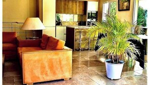 A modern living room with a sofa, a coffee table, and a potted plant. - Bastide standing CLIMATISÉ center town à PIEDS (Aix-en-Provence)