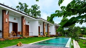 A modern house with a swimming pool, wooden deck, and outdoor seating. - Ancala Uluwatu (Pecatu)