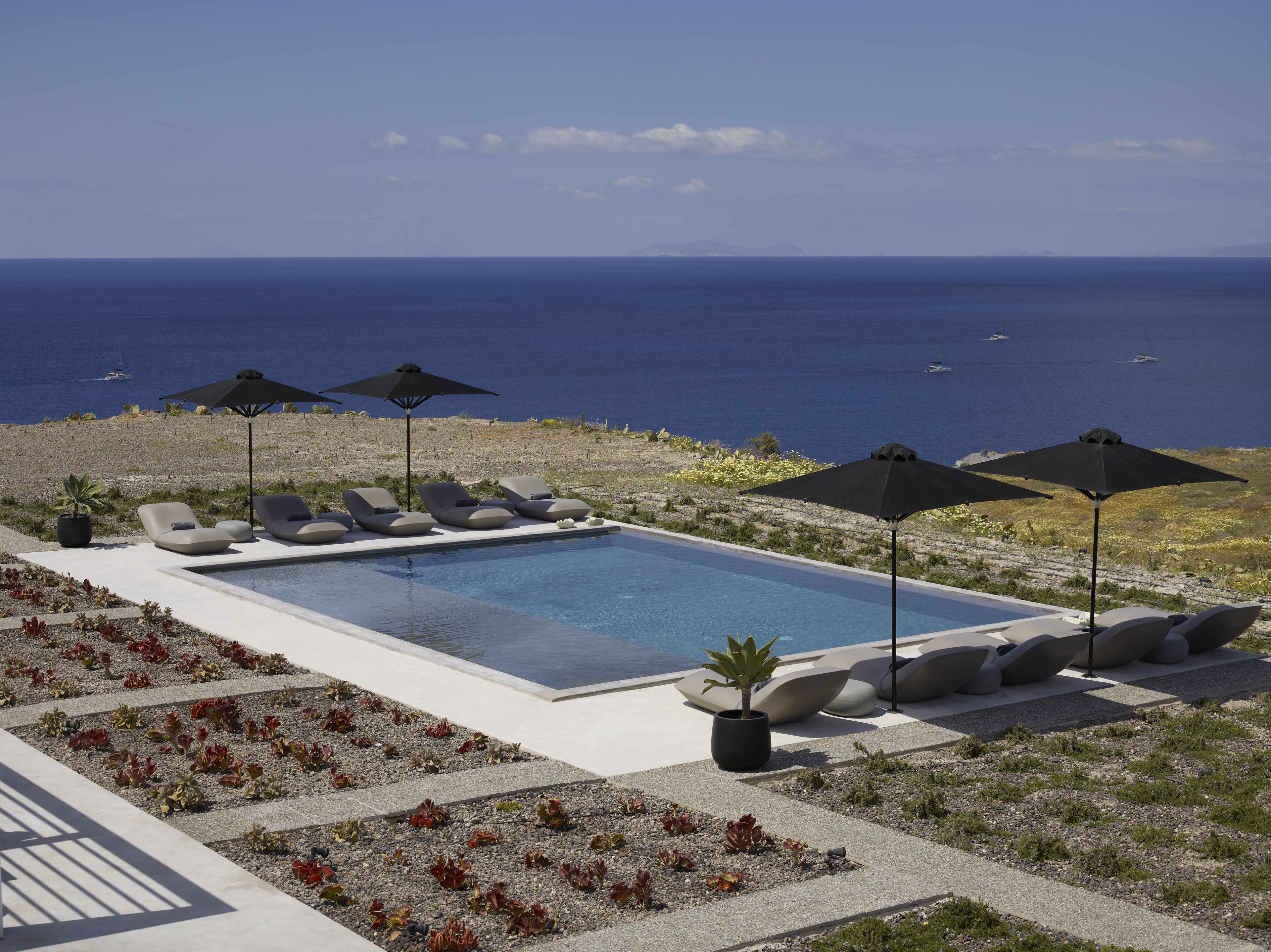 Una piscina al aire libre de temporada, sombrillas