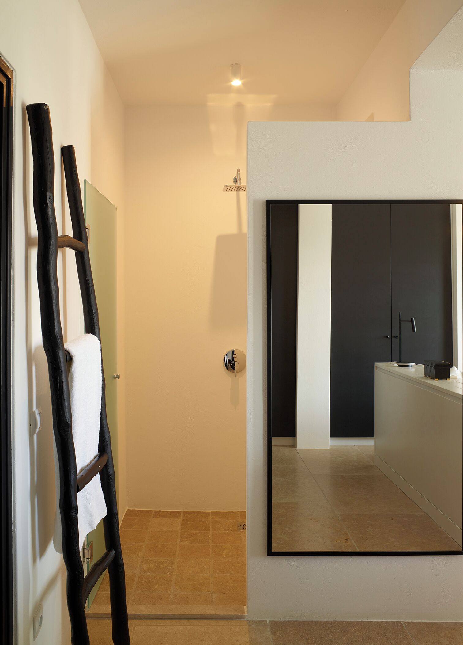 Un bagno moderno con uno specchio grande, un mobile scuro e un porta asciugamani.