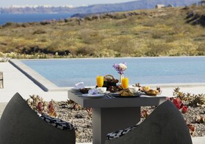 A table with breakfast items and a view of the sea. - Absolute Paradise Santorini- Adults Only (Santorini)