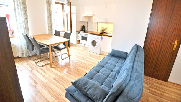 A compact living space with a dining area, kitchenette, and a sofa. - Apartment with one extra bedroom (Fürstenfeld)