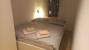 A small, cozy bedroom with a bed, pillows, and a bedside lamp. - Apartment with one extra bedroom (Fürstenfeld)