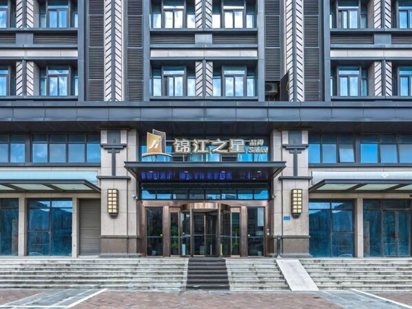 A modern building with a prominent entrance, large windows, and a sign indicating a hotel or accommodation. - Jinjiang Inn Select Suzhou Shengze Sunhuxilu Hotel (Suzhou)
