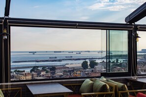 A view from a high-rise building overlooking a harbor with multiple ships, a cityscape, and a clear sky. - Grand Balyan Hotel & Restaurant (Istanbul)