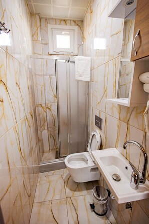 A bathroom with a shower, toilet, sink, and a mirror. - Grand Balyan Hotel & Restaurant (Istanbul)