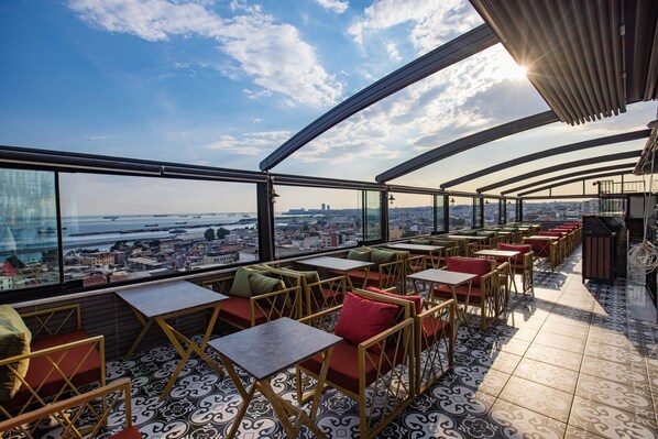 A rooftop terrace with outdoor seating, a view of the city, and a clear sky. - Grand Balyan Hotel & Restaurant (Istanbul)