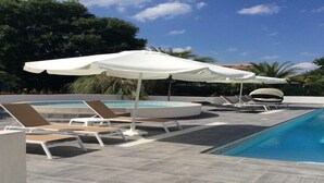 Area piscina con lettini e ombrelloni.