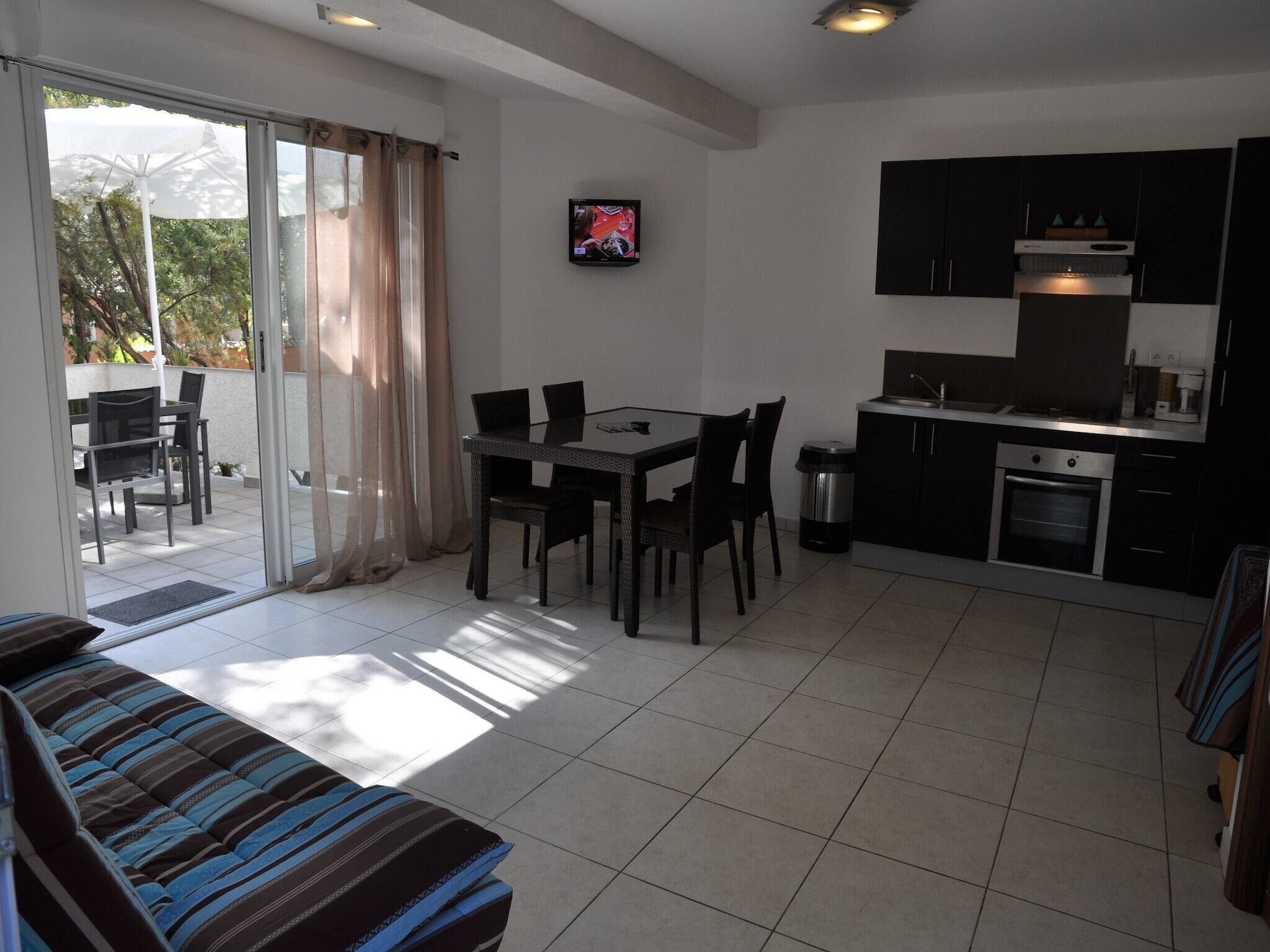 Et moderne køkken med spiseplads, en sofa og en skydedør til en udendørs terrasse.