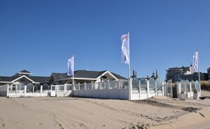 A beachfront property with multiple white buildings, some with glass facades.