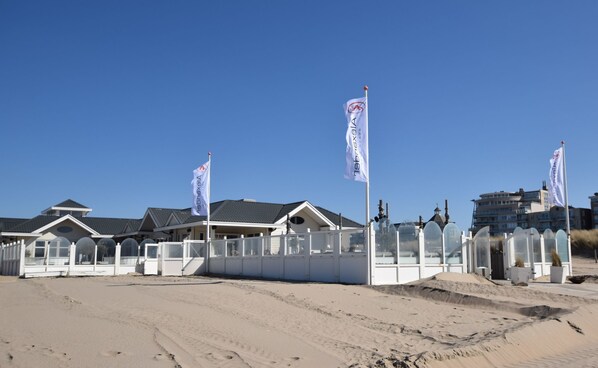 Una propiedad frente a la playa con varios edificios blancos, algunos con fachadas de vidrio.