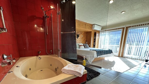 A modern bathroom with a large bathtub, red tiles, and a glass-enclosed shower. - Luxury Hunter Mountain View Townhome -Pool-Fire pit-Walk to Scribner’s-Sleeps 10 (Hunter)