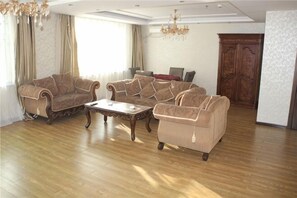 A living room with a sofa set, a coffee table, and a chandelier. - Beiyuan Hotel (Sunwu)
