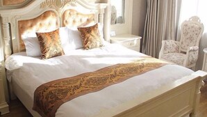 Cama com cabeceira, duas almofadas e um objeto decorativo.