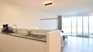 A modern kitchen with a central island, a built-in sink, and a coffee maker.