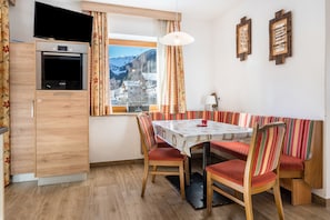 A dining area with a table, chairs, and a bench.