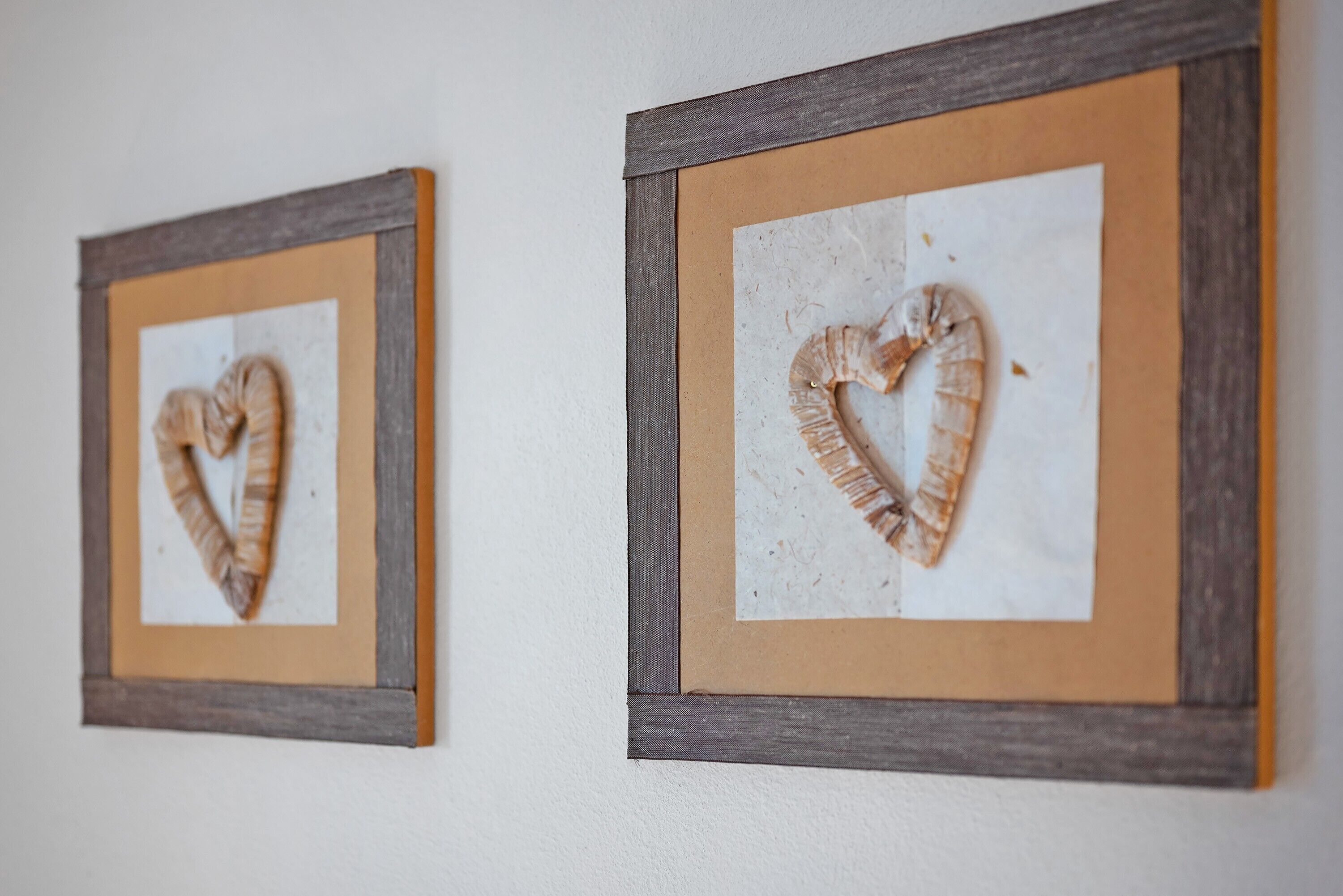 Two framed wall art pieces with a heart shape.