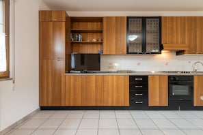 A kitchen with wooden cabinets, a built-in oven, and a tiled backsplash.