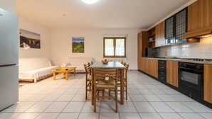 Une cuisine moderne avec des meubles en bois, une table à manger et un four encastré.