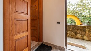 A wooden door leading to a stone-walled area with a yellow archway. - Apartment Casa Colonia 1 with Sea View, Shared BBQ and Wi-Fi (Sant'Anna Arresi)