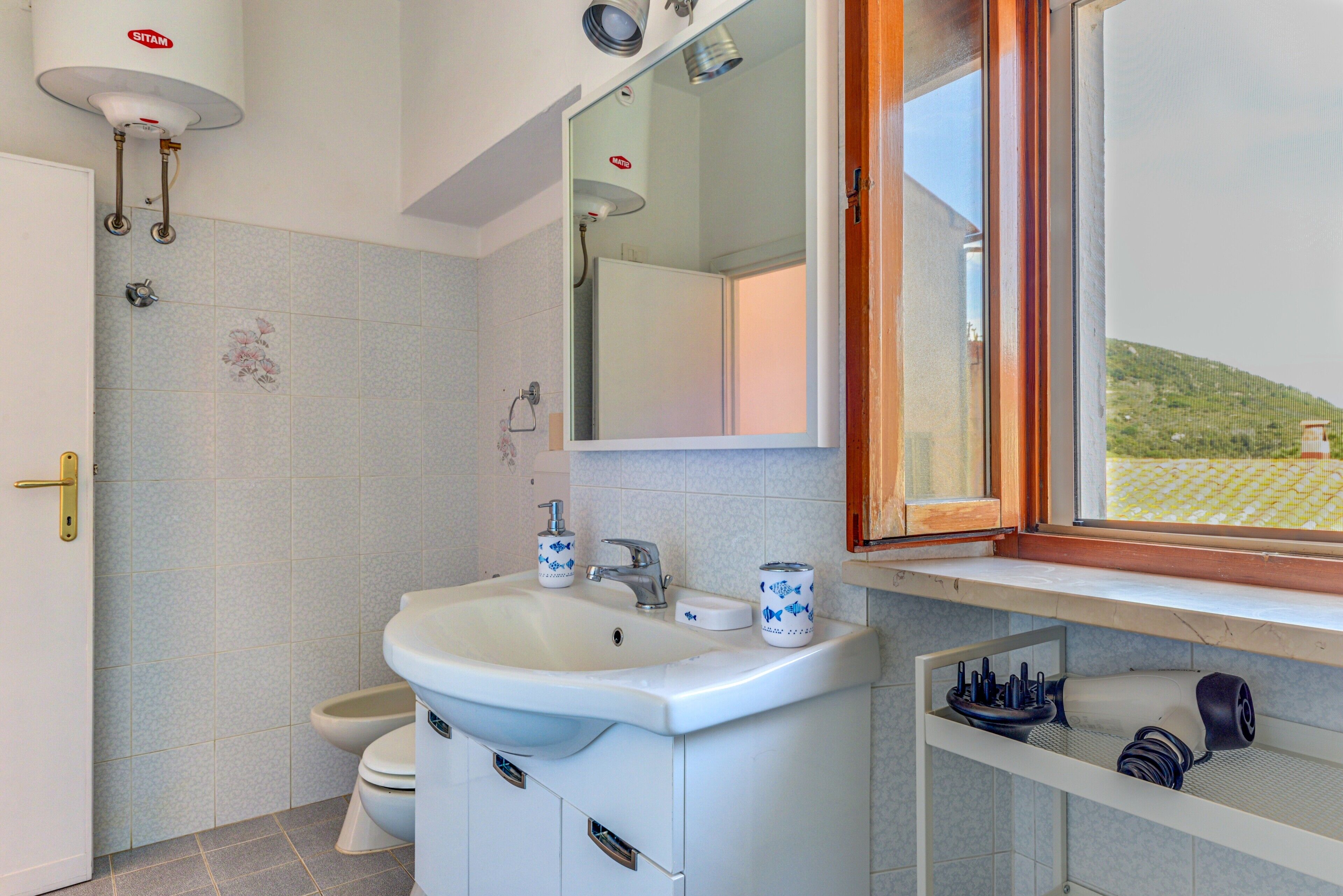 Une salle de bain avec un lavabo, des toilettes et un miroir au-dessus du lavabo.
