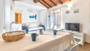 Una stanza con un tavolo apparecchiato per mangiare, una televisione e un muro con una mappa.