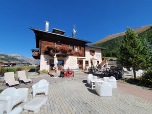 Un bâtiment de style chalet doté d’un espace extérieur aménagé et offrant une vue sur les montagnes.