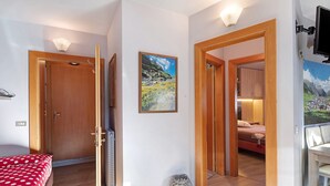 Ein Hotelzimmer mit einem Bett, einer Holztür, einem Gemälde und einem Fernseher.