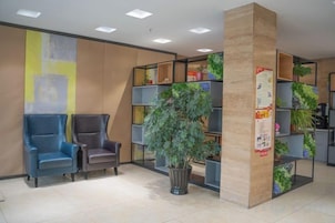 A reception area with seating, a plant, and a bulletin board.