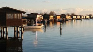 Une série de structures en bois flottantes, situées sur une étendue d’eau calme, probablement utilisées à des fins d’hébergement ou de loisirs.