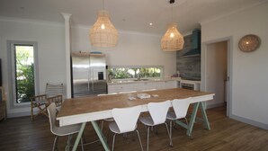 A modern kitchen with a large island, stainless steel appliances, and pendant lighting. - Sandy Toes Beach House (HORSESHOE BAY)